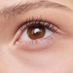 Detailed close-up of a woman's eye showcasing natural makeup and well-groomed eyebrow.