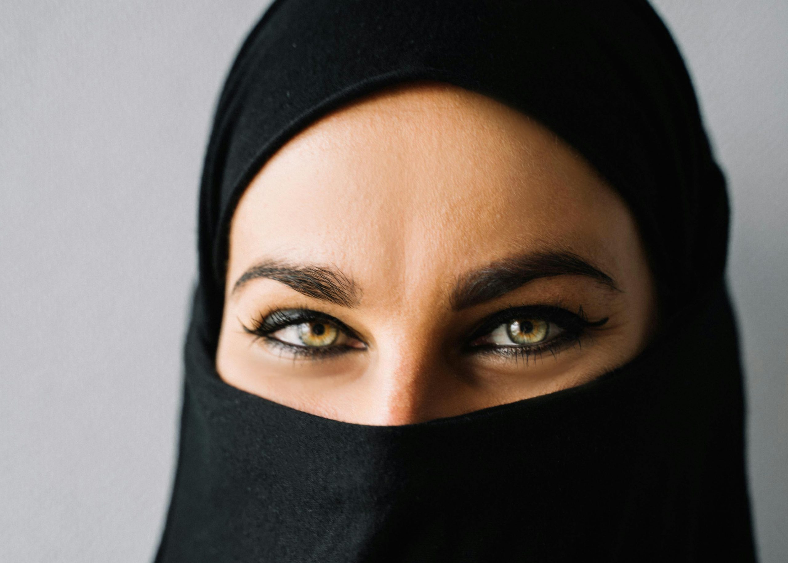 A captivating close-up of a woman in a hijab emphasizing her striking eyes and expressive gaze.