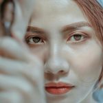 Intimate close-up portrait of a young woman with a calm expression, highlighting her natural beauty.