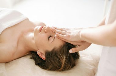 Woman enjoying a peaceful head massage in a serene spa environment.